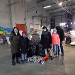 Rodzice i wolontariusz pomagają przy wypakowaniu zakrętek dla Hani