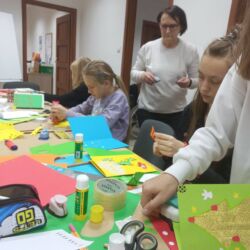 Wolontariusze wykonują kartki swiąteczne dla podopiecznych Fundacji ,,Okno Nadziei"