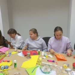 Wolontariusze wykonują kartki swiąteczne dla podopiecznych Fundacji ,,Okno Nadziei"