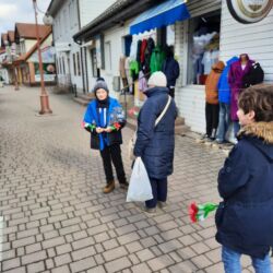 Uczniowie wręczają kwiaty paniom z okazji Dnia Kobiet